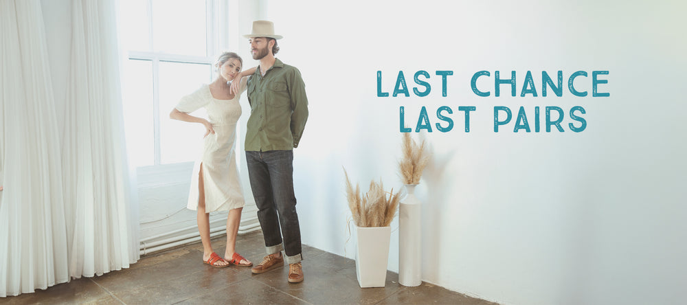 A woman and a man stand next to each other in a bright room. The wall text reads "LAST CHANCE LAST PAIRS". Two white vases with dried plants are in the corner.