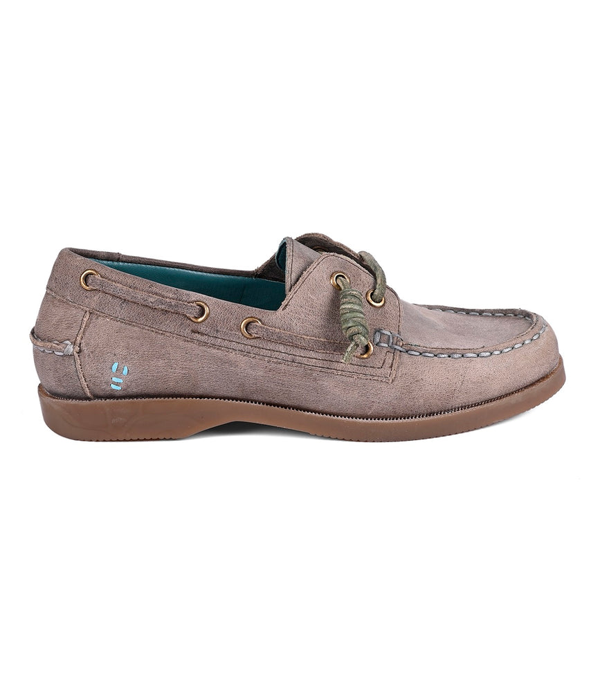 Side view of Roan's Abide women's leather boat shoe with green laces, brown sole, blue inner lining, visible stitching, metal eyelets, and a durable runner composite outsole. This shoe blends timeless elegance with functionality.