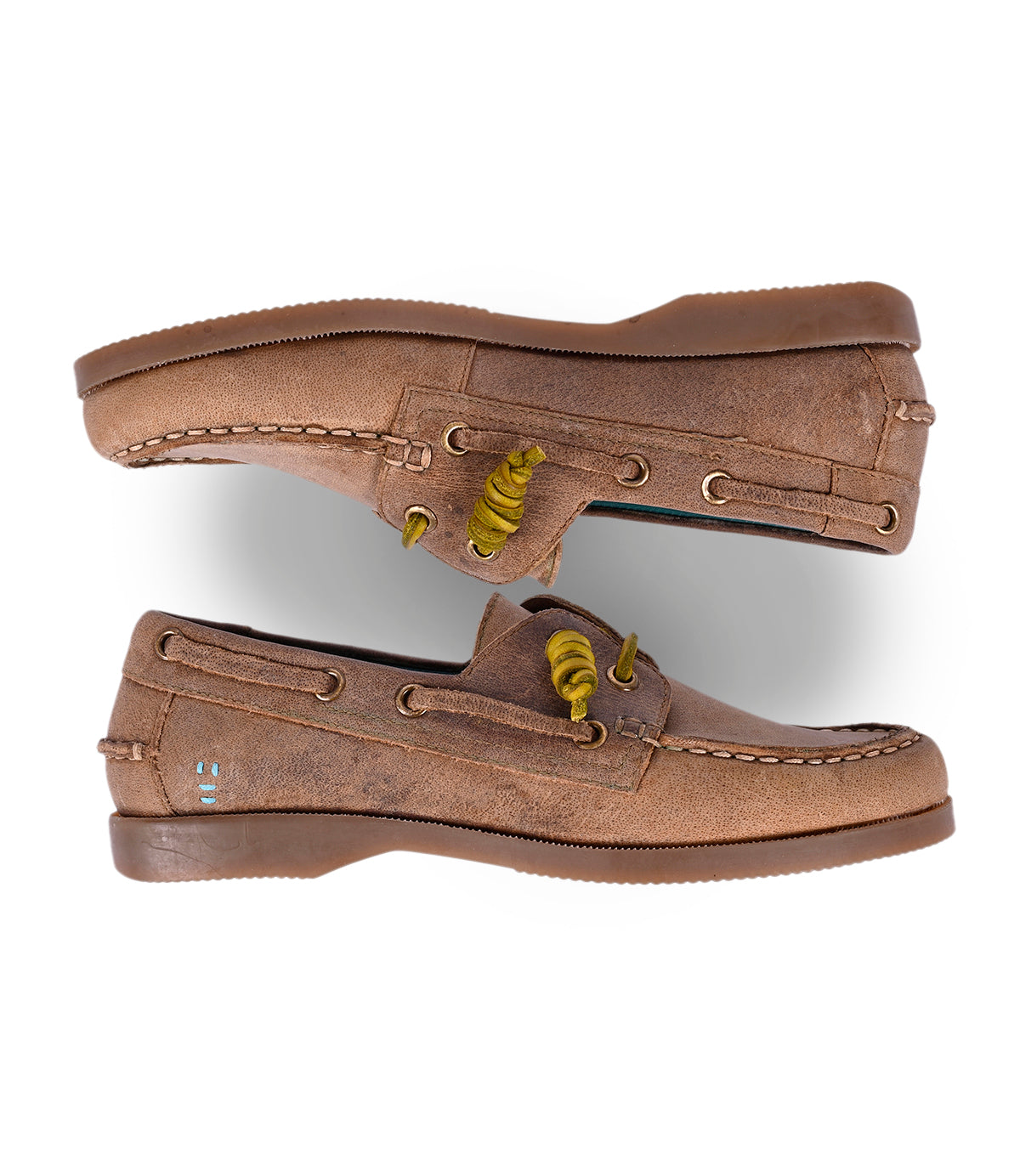 
                  
                    Roan's Abide women’s boat shoes in brown leather feature yellow laces, decorative stitching, and a flag emblem. Seen from the side, these shoes have a rotating perspective and a runner composite outsole for enhanced water repellency.
                  
                