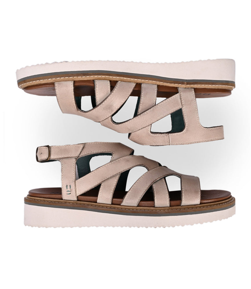 
                  
                    Roan's Centrist sandals, featuring a leather fisherman design in beige with a metal buckle closure and white soles, are elegantly displayed side by side on a white background.
                  
                