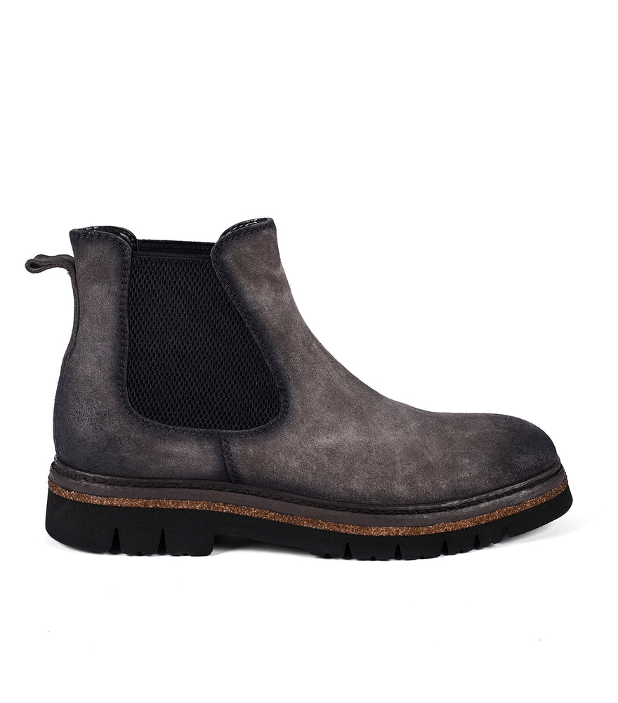 
                  
                    The Roan Defy is a single dark gray Chelsea boot with black elastic side panels, a pull tab, a textured rubber sole for traction, and exquisite hand-finishing.
                  
                