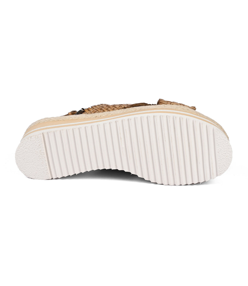 
                  
                    The image showcases Roan's "Into" shoe, featuring a textured white foam outsole with serrated details and a tan upper, exemplifying artisanal craftsmanship.
                  
                