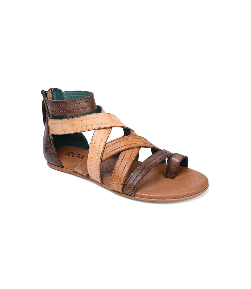 The Roan "Royalty" sandal is brown and tan leather, offering a strappy gladiator style with a flat sole and back zipper closure for easy wear.