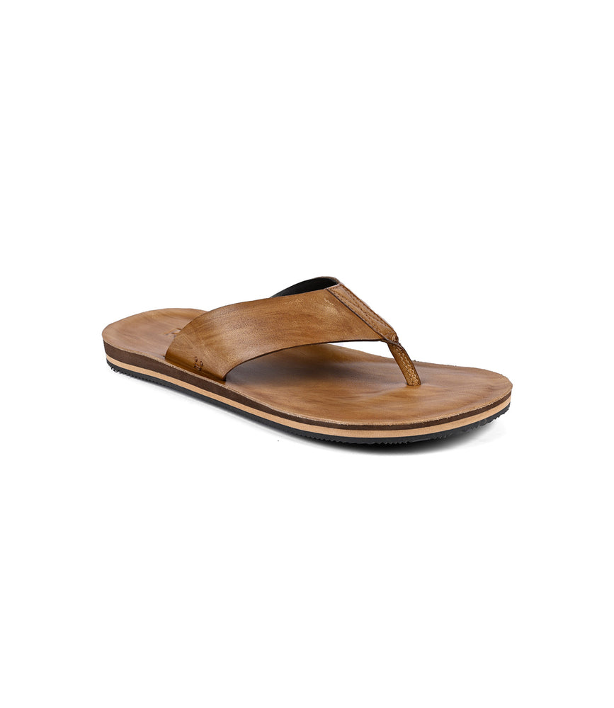 The Roan Townfolk sandal is a brown leather flip-flop with a thong strap and flat sole, showcasing rustic charm, pictured at an angle against a white background.