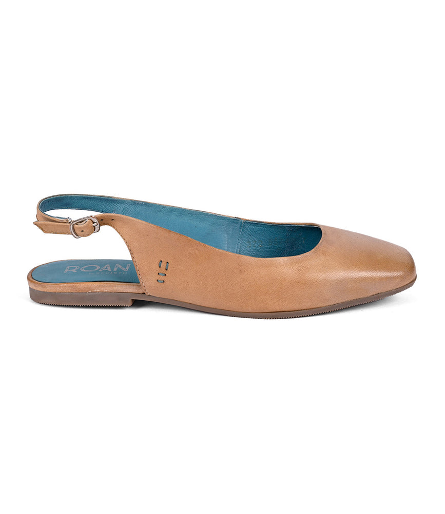 
                  
                    The Roan Woken shoe boasts a tan leather upper with an elegant slingback style, featuring a blue insole and a back strap accented by a small buckle.
                  
                