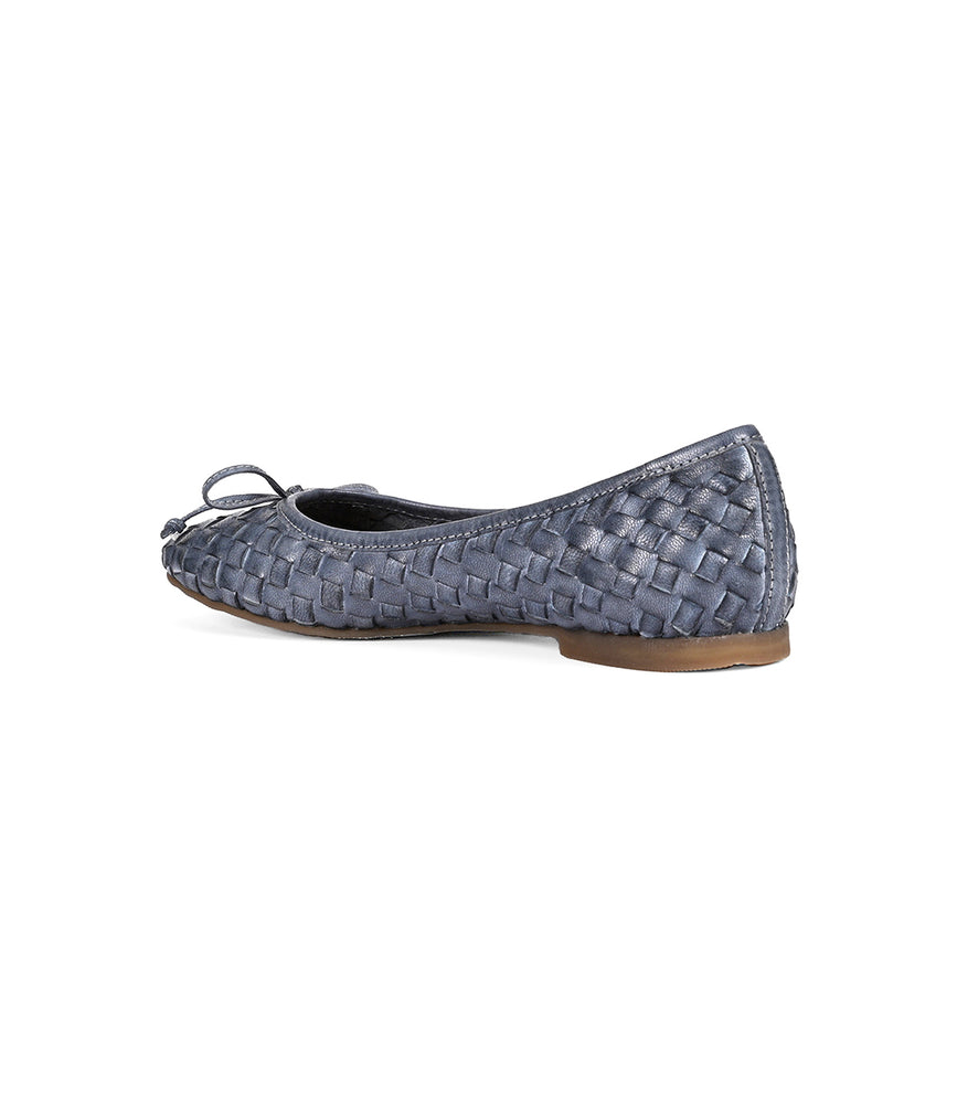 
                  
                    Side view of a blue hand-woven leather flat shoe with a small bow on the front and a low heel, showcasing intentional craftsmanship by Roan Business.
                  
                