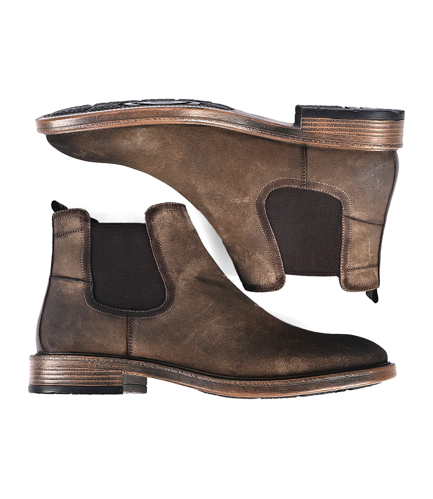 
                  
                    The Jardeen by Roan features two versatile brown Chelsea boots crafted from suede, complete with elastic side panels and wooden soles, ensuring an easy slip-on experience. Seen from the side and top, these boots seamlessly combine style with practicality.
                  
                