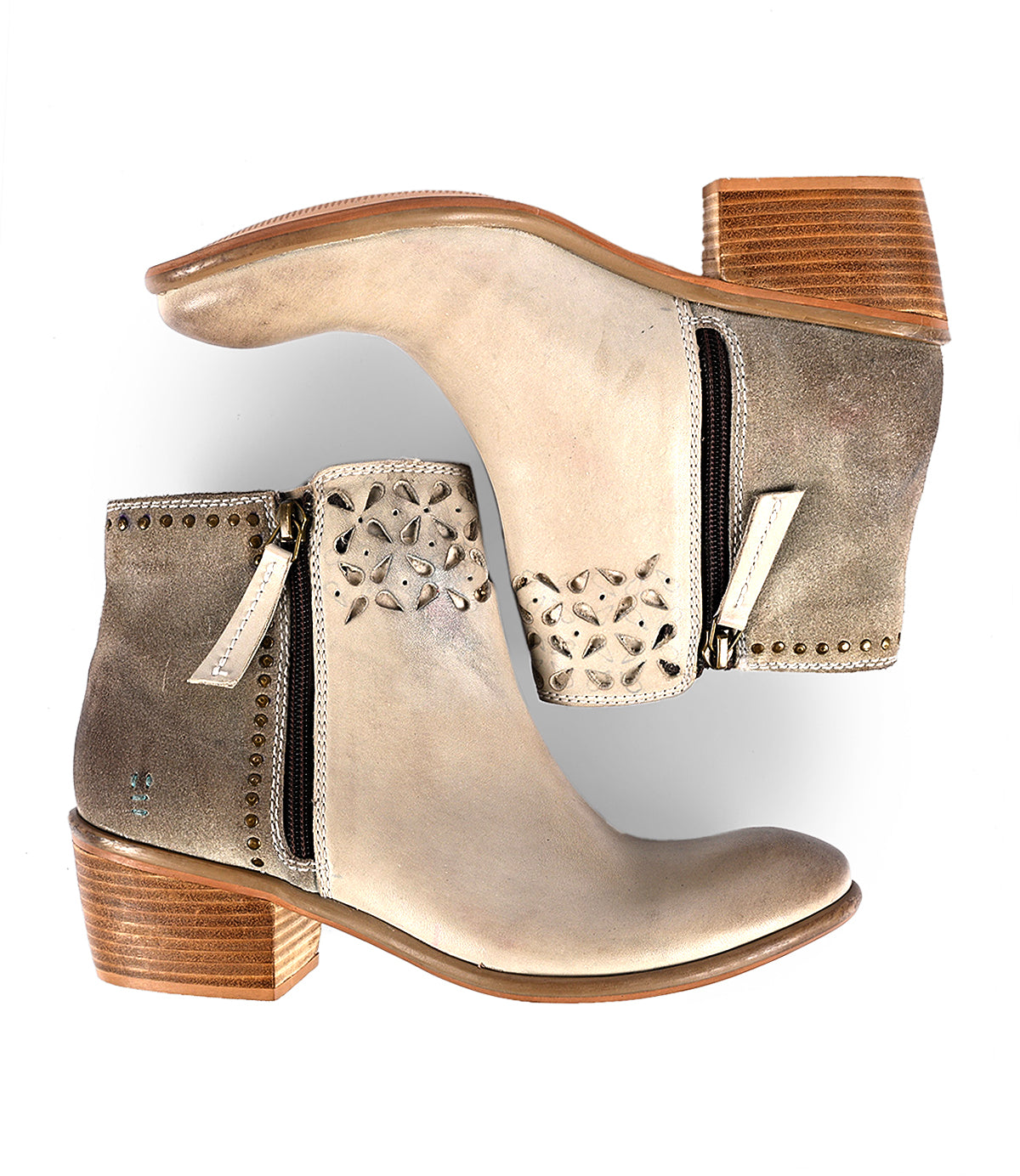 
                  
                    The Liz Cutout ankle boots by Roan are tan with decorative cutouts, side zippers, wooden block heels, and gold rivet details.
                  
                