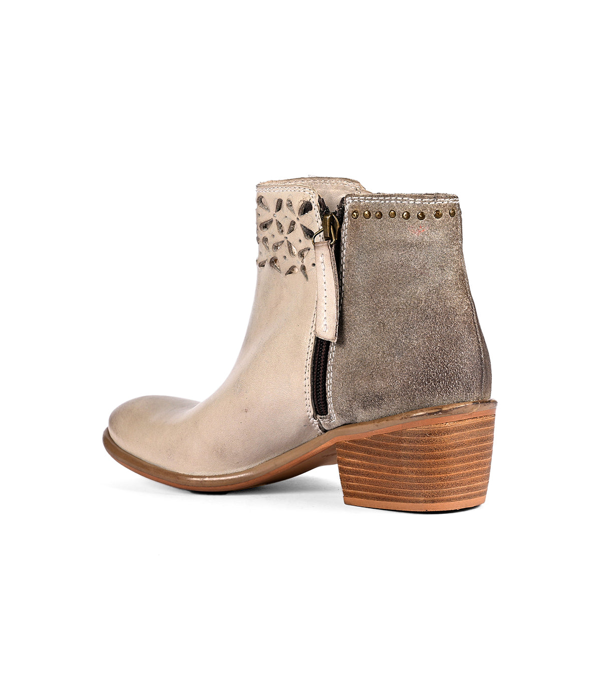 
                  
                    The Liz Cutout by Roan is a beige ankle boot featuring a side zipper, decorative perforations, gold rivet details, and a wooden block heel, showcased from a side angle.
                  
                