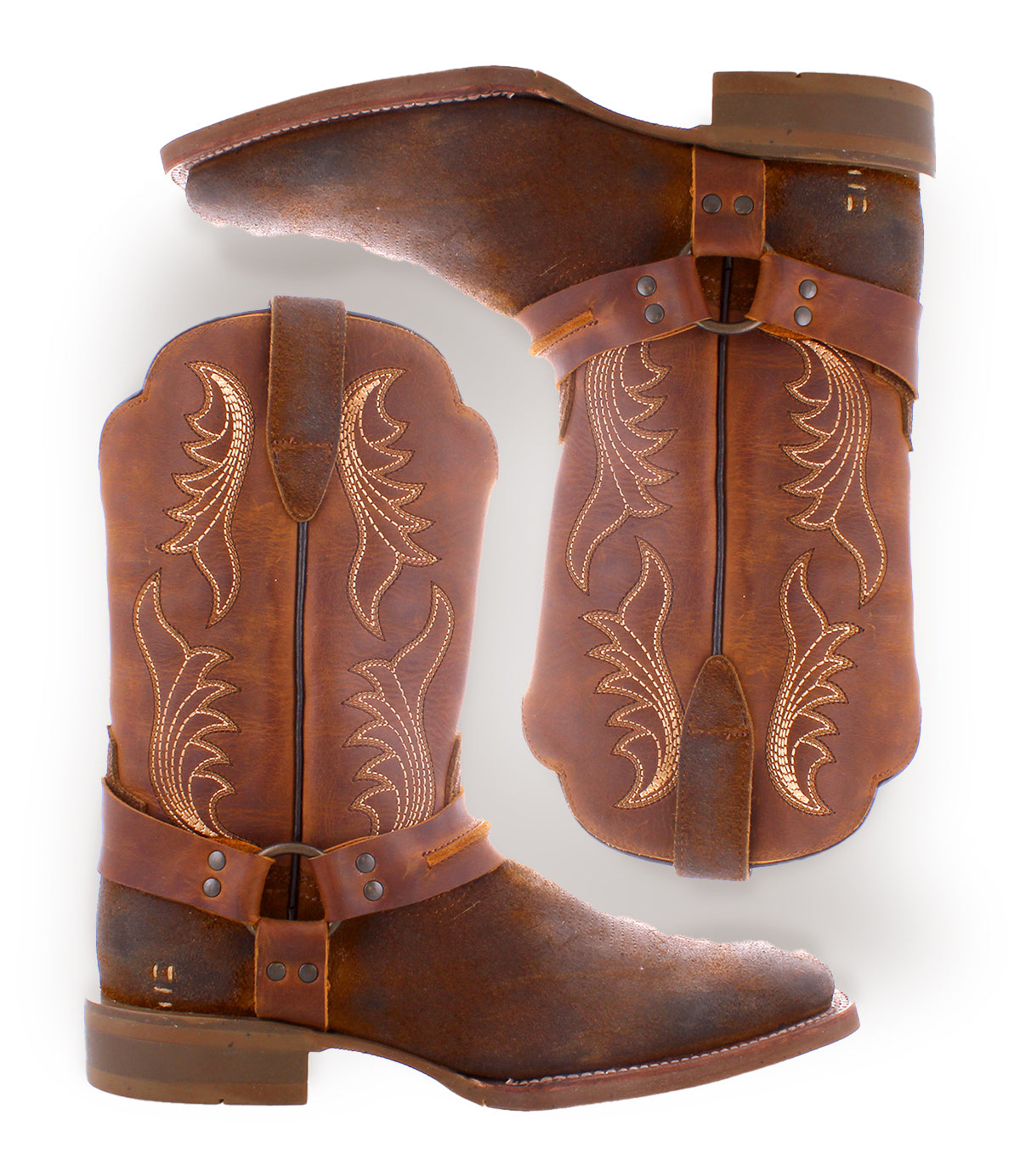 
                  
                    Two Saga boots by Roan, made from premium brown leather and adorned with decorative stitching, lie on their sides, highlighting the stylish look of the sides and soles.
                  
                