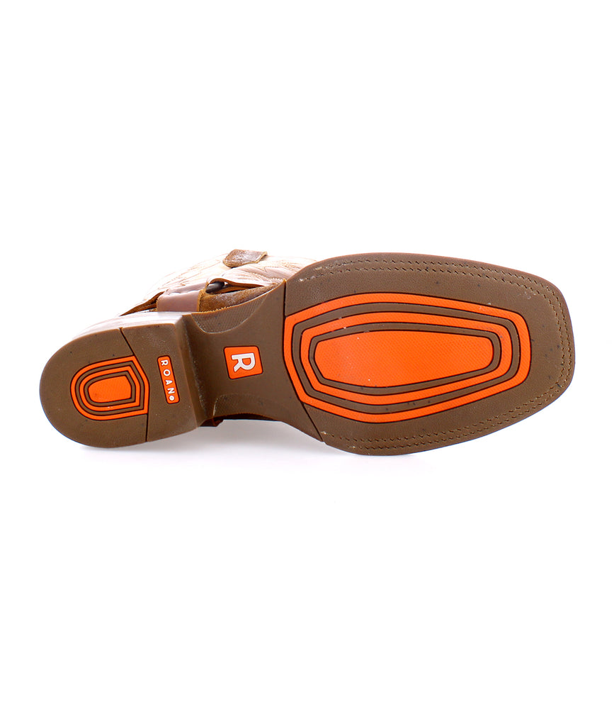 
                  
                    The image displays the sole of Roan's Saga brown shoe, featuring orange accents and a textured grip pattern. Crafted from premium leather, it showcases the brand logo.
                  
                